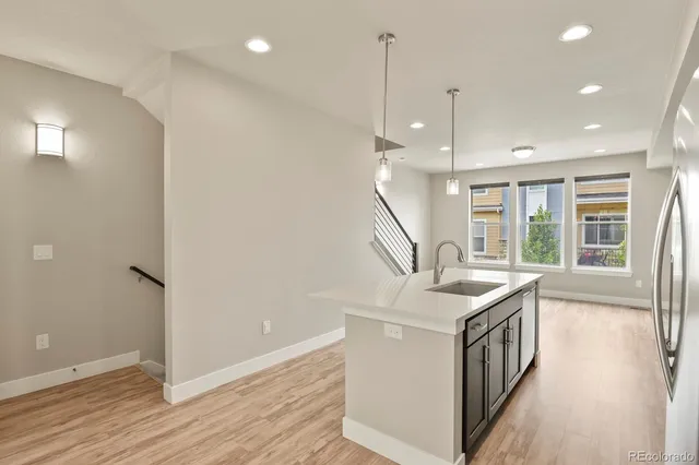 a open kitchen with a sink a stove and a wooden floor