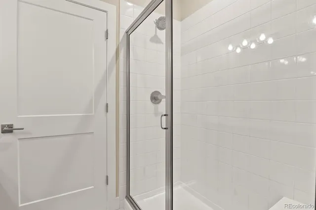 a bathroom with a shower and a glass door
