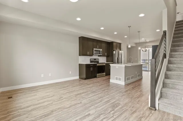 a kitchen with stainless steel appliances kitchen island granite countertop a stove and a refrigerator