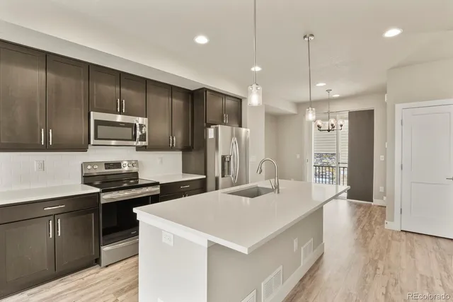 a kitchen with refrigerator cabinets and wooden floor