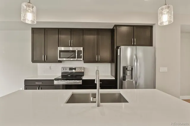 a kitchen with granite countertop a refrigerator and a sink