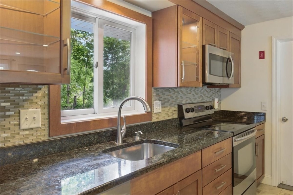 15 Temi Road Beverly, MA 01915 - Photo 13 of 41 a kitchen with granite countertop a sink a counter top space cabinets and stainless steel appliances