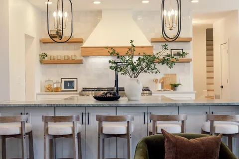 a kitchen with stainless steel appliances kitchen island granite countertop a table chairs and a wooden floor