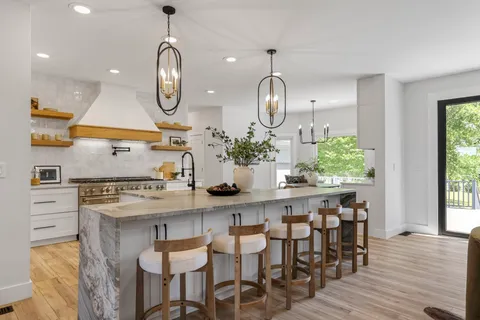 a living room with furniture chandelier and view of kitchen
