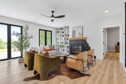 a living room with fireplace furniture and a potted plant