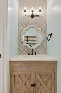 a bathroom with a sink a toilet a mirror and shower