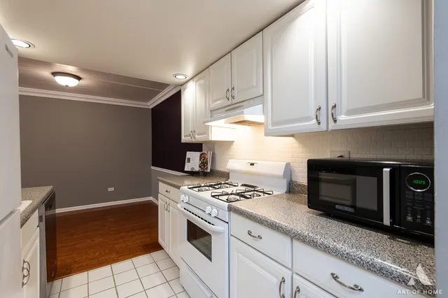 a kitchen with granite countertop a stove a sink and a microwave