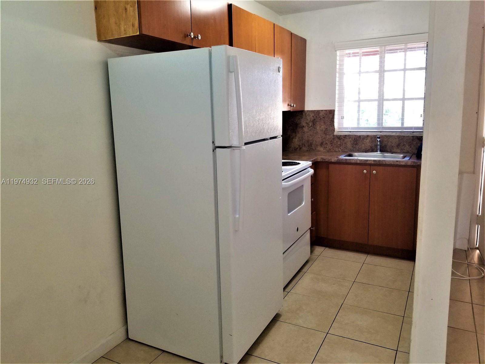 50 West 4th Street, Unit 13 Hialeah, FL 33010 - Photo 4 of 5 a white refrigerator freezer and a stove sitting inside of a kitchen