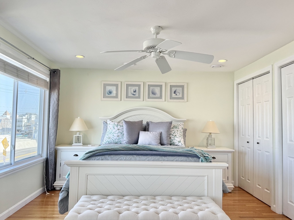 181 Atlantic Avenue Hull, MA 02045 - Photo 14 of 42 a bedroom with a large bed and a chandelier