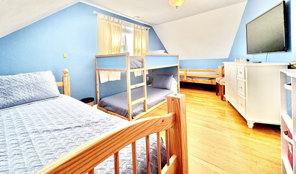 181 Atlantic Avenue Hull, MA 02045 - Photo 30 of 42 a bedroom with a bed and a flat tv screen next to a window