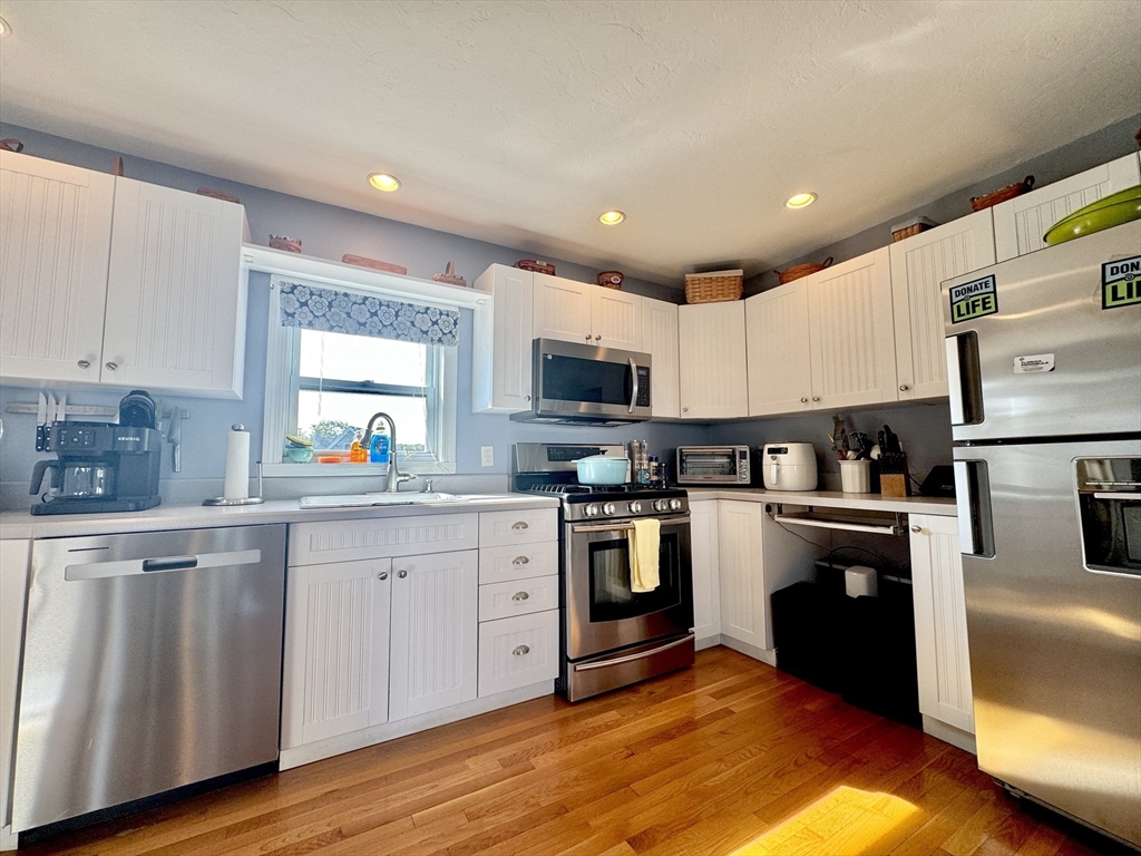 181 Atlantic Avenue Hull, MA 02045 - Photo 5 of 42 a kitchen with granite countertop stainless steel appliances and wooden cabinets