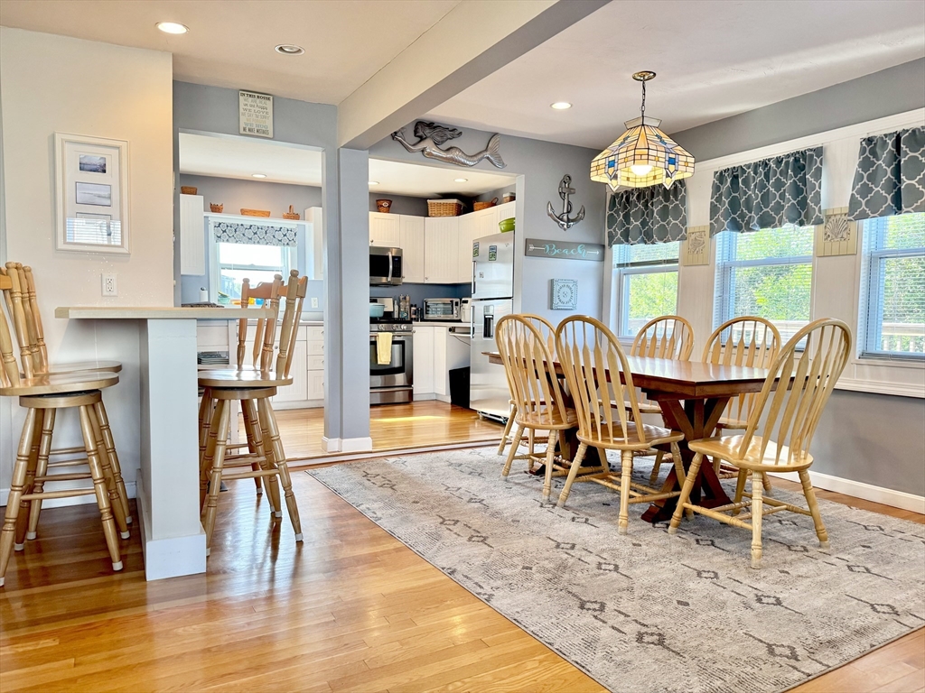 181 Atlantic Avenue Hull, MA 02045 - Photo 8 of 42 a view of a dining room with furniture a chandelier and wooden floor