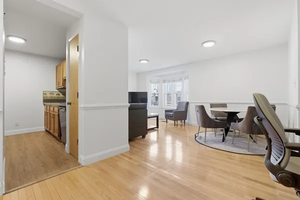 a view of a dining room with furniture a rug and wooden floor