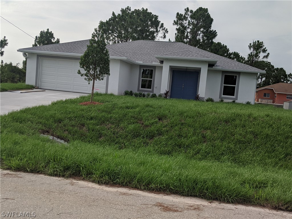 2930 18th Street Southwest Lehigh Acres, FL 33976 - Photo 1 of 20 a front view of house with yard and green space