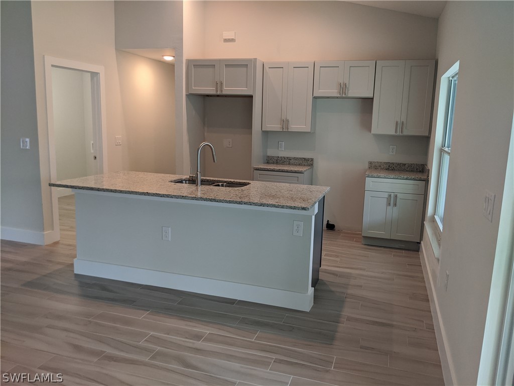 2930 18th Street Southwest Lehigh Acres, FL 33976 - Photo 11 of 20 a kitchen with stainless steel appliances granite countertop a sink stove and refrigerator