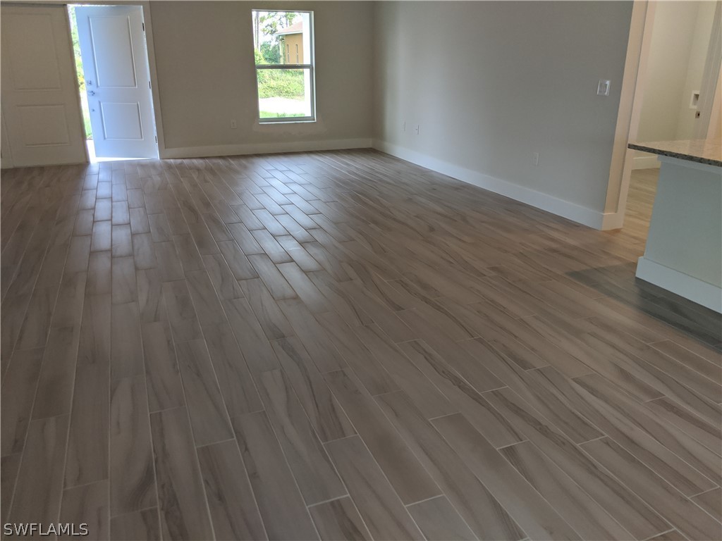 2930 18th Street Southwest Lehigh Acres, FL 33976 - Photo 12 of 20 an empty room with wooden floor and windows