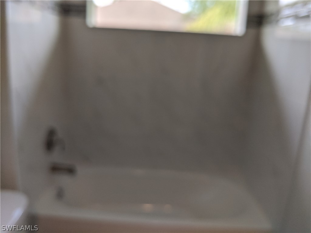 2930 18th Street Southwest Lehigh Acres, FL 33976 - Photo 16 of 20 a close up of a bathtub in a bathroom