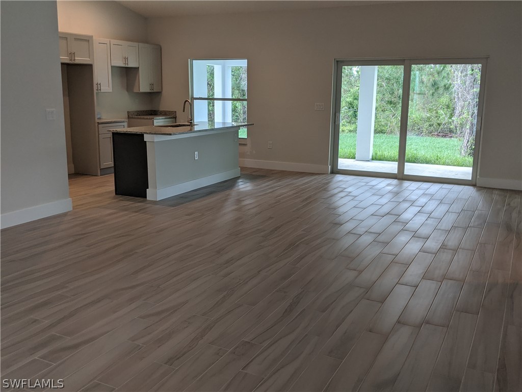 2930 18th Street Southwest Lehigh Acres, FL 33976 - Photo 19 of 20 a large kitchen with cabinets wooden floor and stainless steel appliances