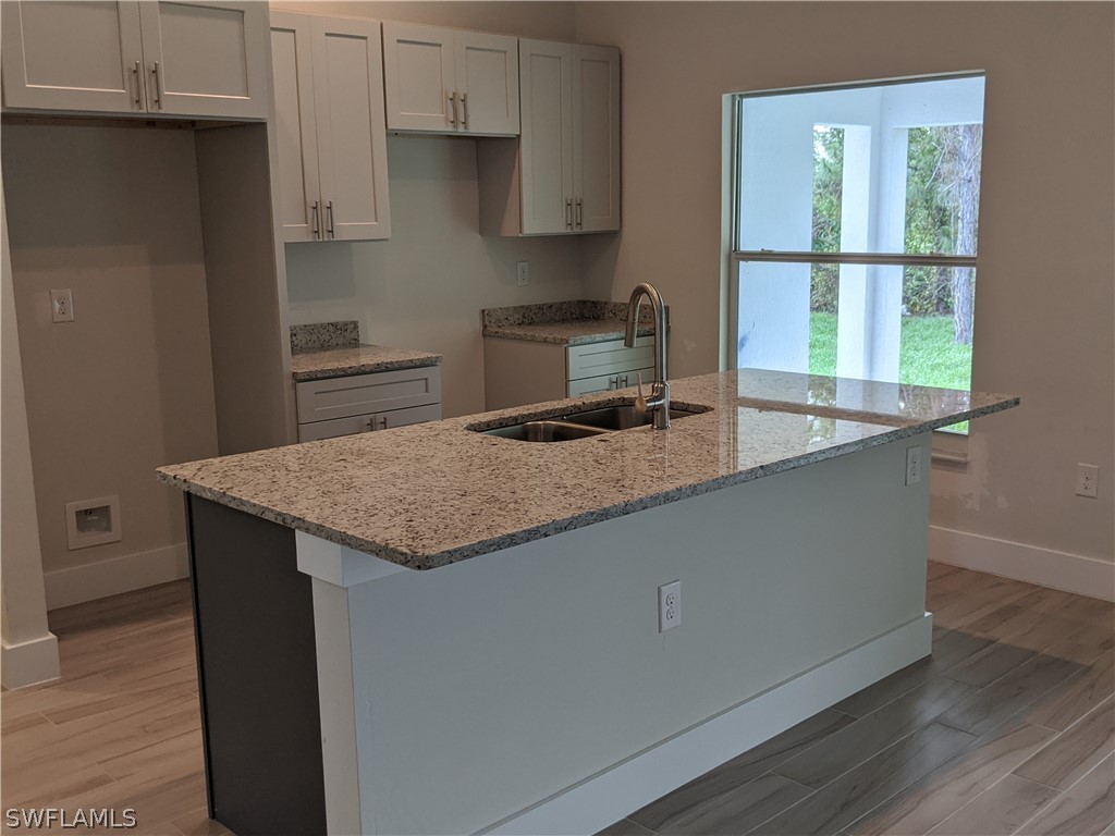 2930 18th Street Southwest Lehigh Acres, FL 33976 - Photo 9 of 20 a kitchen with granite countertop a sink a counter top space and cabinets