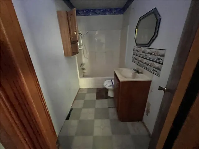 a bathroom with a sink a toilet a mirror and shower
