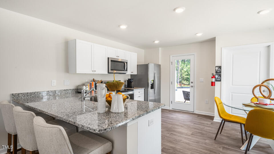 8746 Asher Gray Way Raleigh, NC 27616 - Photo 5 of 29 a kitchen with a table chairs and refrigerator