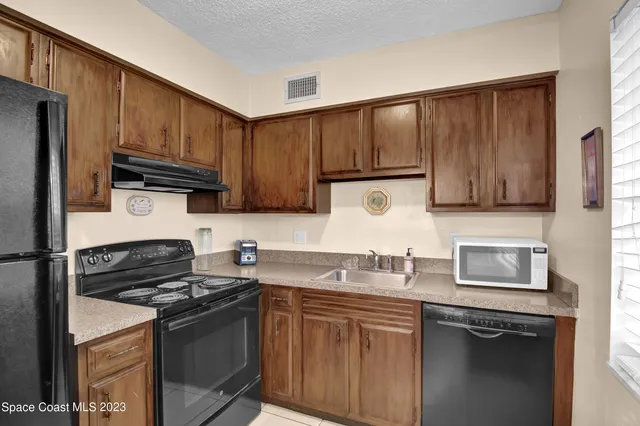 a kitchen with granite countertop a sink stove and microwave