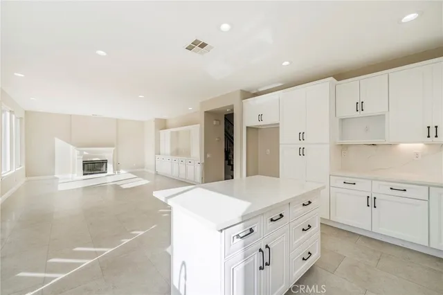 a kitchen with granite countertop white cabinets and refrigerator