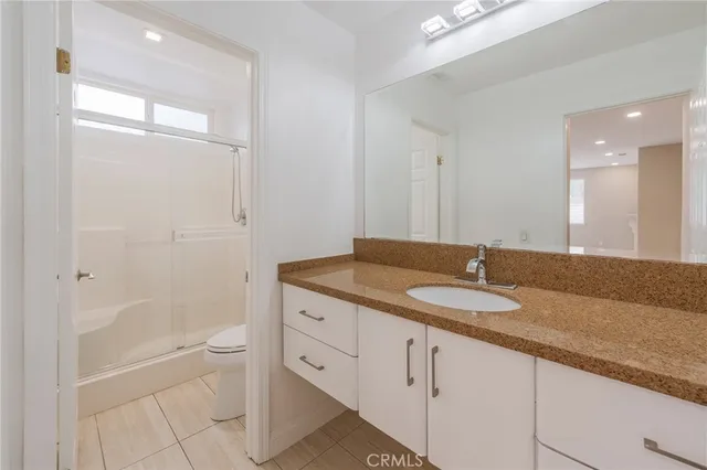 a bathroom with a granite countertop sink a toilet and bathtub