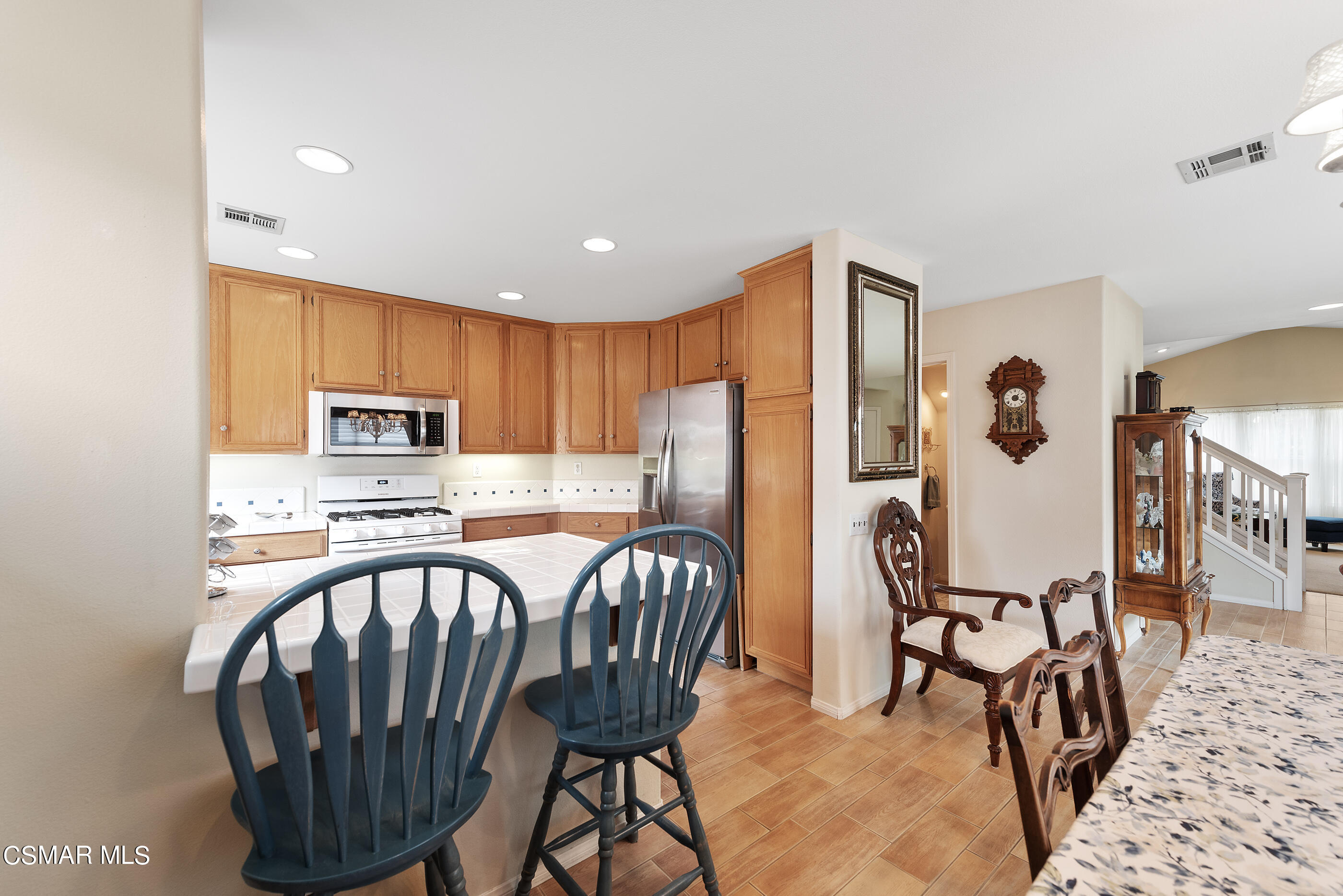 5642 Daisy Street Simi Valley, CA 93063 - Photo 13 of 41 a kitchen with stainless steel appliances granite countertop a stove a refrigerator a sink a table and chairs