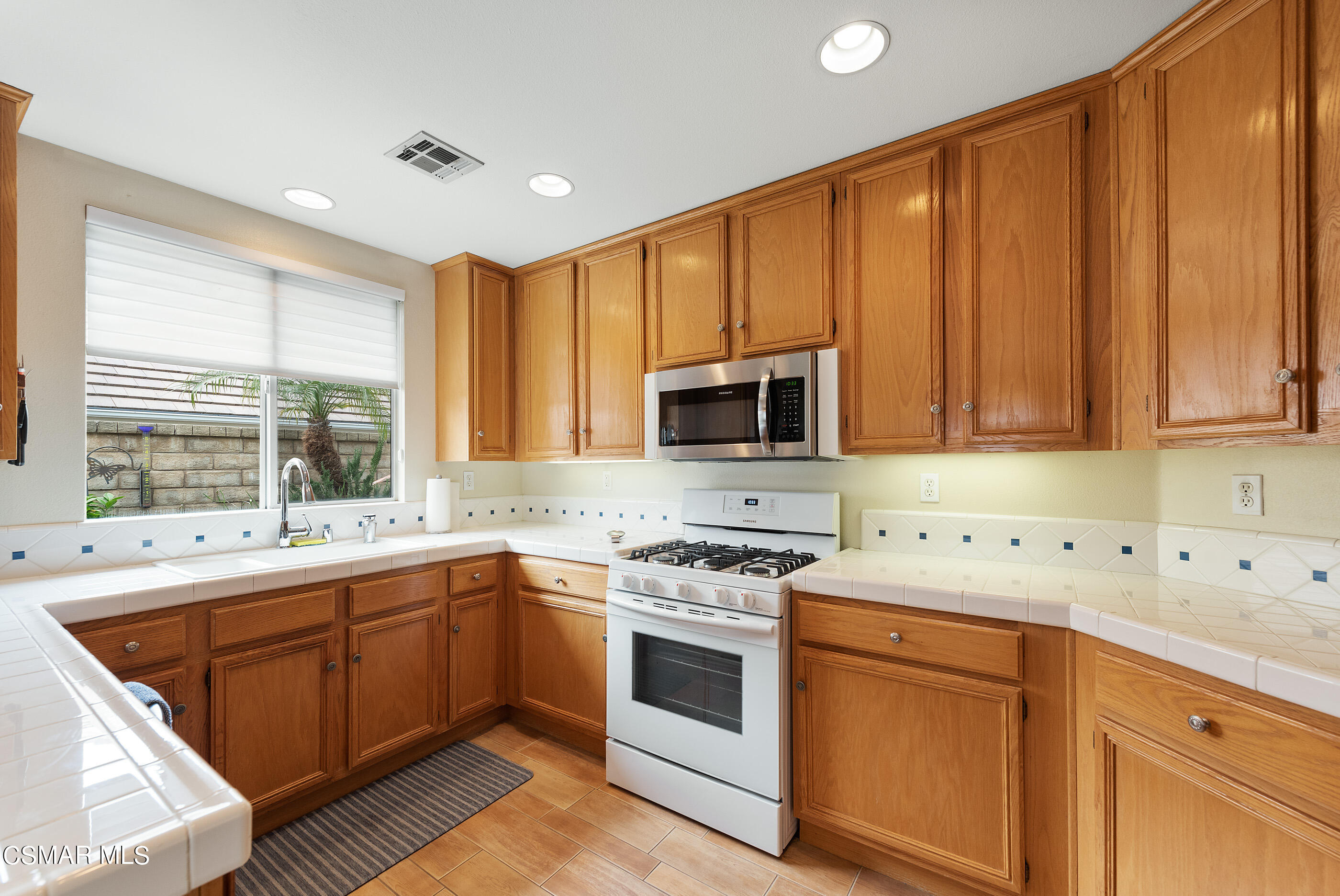 5642 Daisy Street Simi Valley, CA 93063 - Photo 14 of 41 a kitchen with stainless steel appliances a sink stove and cabinets