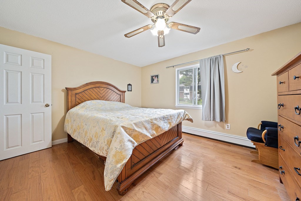 35 Will Drive, Unit 3 Canton, MA 02021 - Photo 11 of 18 a bedroom with a bed and wooden floor