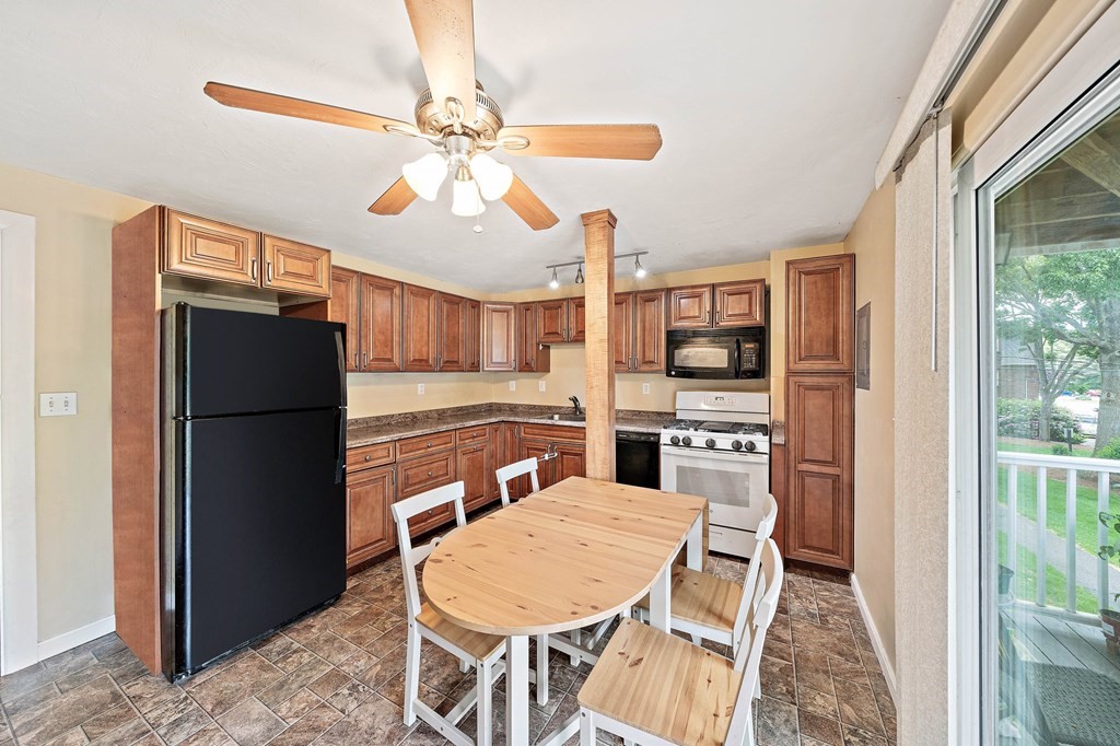 35 Will Drive, Unit 3 Canton, MA 02021 - Photo 3 of 18 a kitchen with stainless steel appliances granite countertop a refrigerator a stove a sink a oven with a dining table and chairs
