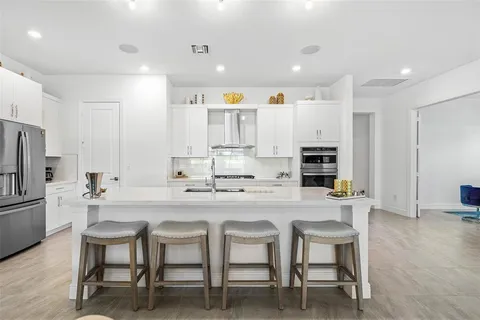 a kitchen with stainless steel appliances kitchen island granite countertop a table and chairs in it