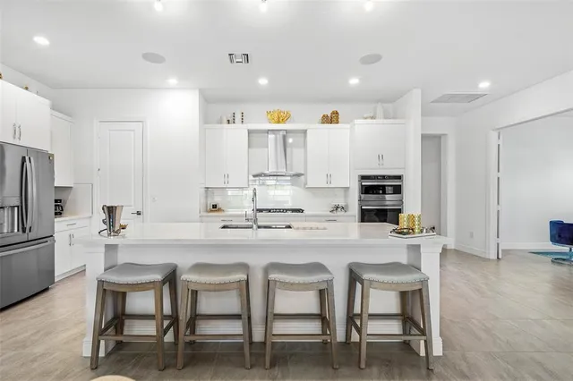 a kitchen with stainless steel appliances kitchen island granite countertop a table and chairs in it