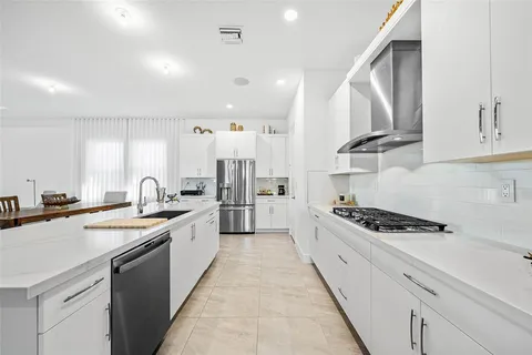 a kitchen with stainless steel appliances a sink stove and cabinets