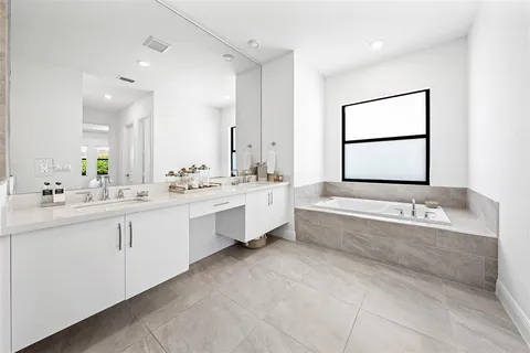 a bathroom with a bathtub a sink and a mirror