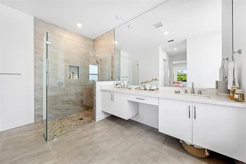 a bathroom with a double vanity sink mirror and shower
