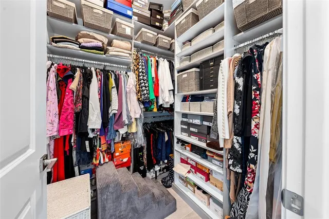 a view of walk in closet with clothes and shoes