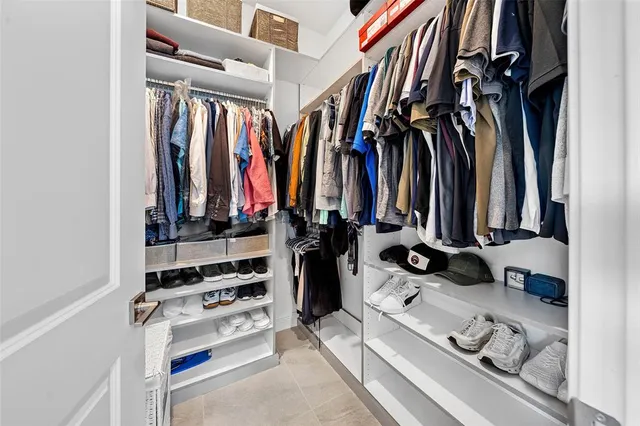 a view of walk in closet with clothes and shoes