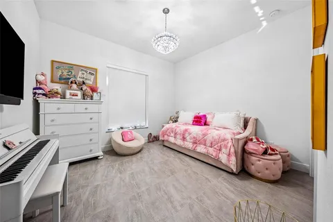 a bedroom with bed and a chandelier