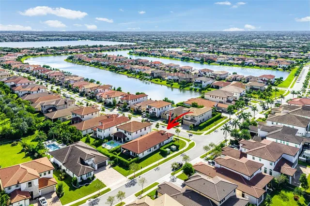 an aerial view of a city with lots of residential buildings ocean and mountain view in back