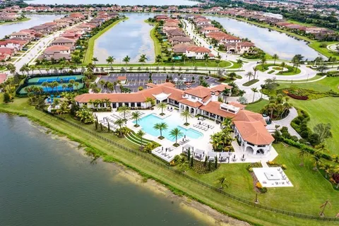 an aerial view of residential houses with outdoor space and lake view