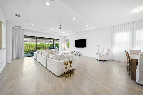 a living room with furniture floor to ceiling window and a flat screen tv