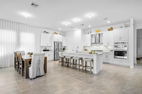 a large kitchen with a table and chairs