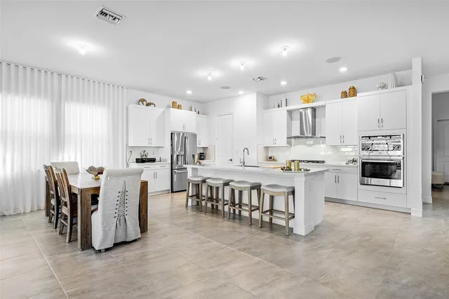 a large kitchen with a table and chairs