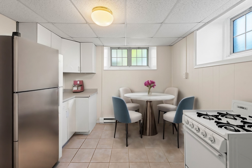 98 Main Street, Unit V Andover, MA 01810 - Photo 8 of 21 a kitchen with stainless steel appliances granite countertop a sink a stove a refrigerator and a dining table