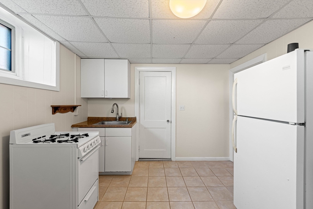 98 Main Street, Unit V Andover, MA 01810 - Photo 9 of 21 a kitchen with a stove a refrigerator and a stove top oven