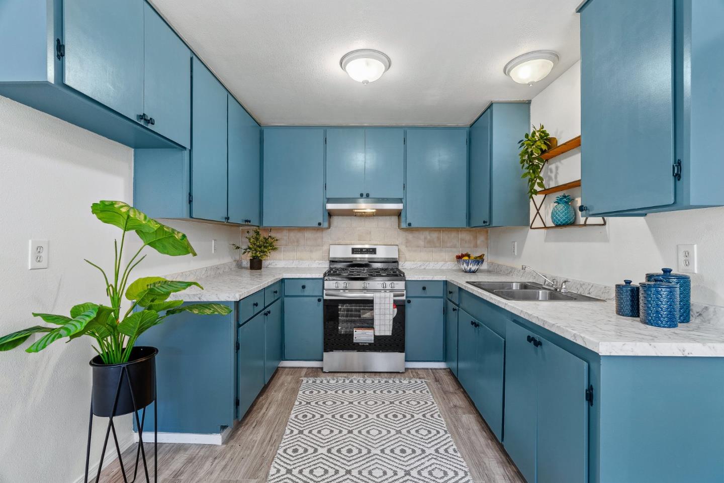 a kitchen with a sink a stove cabinets and stainless steel appliances