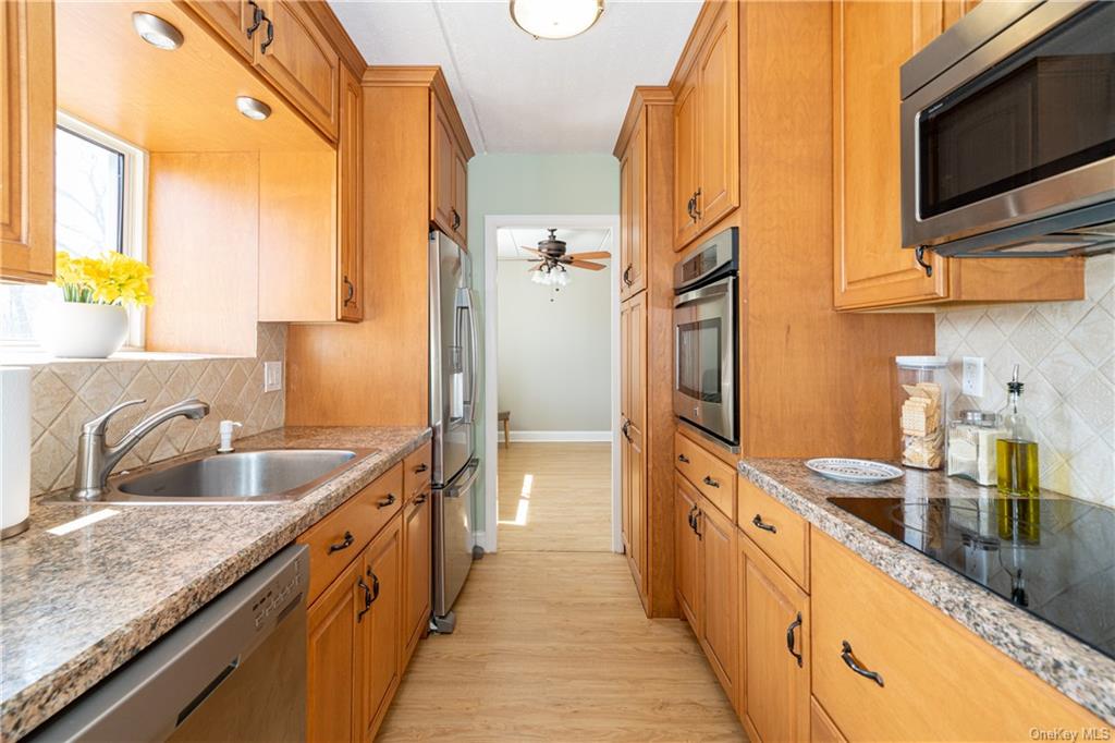 a large kitchen with stainless steel appliances granite countertop a sink and a refrigerator