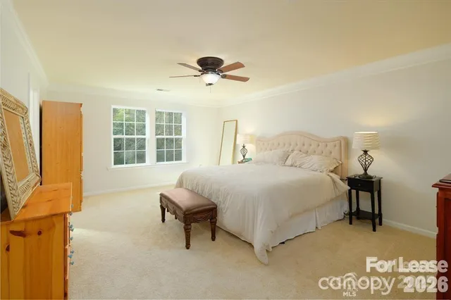 a bedroom with a bed lamps and a large window